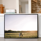 Fotovergroting Posterframe Landscape 4:3, zwart kader met familiefoto in veld bij zonsondergang
