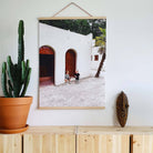 Fotovergroting Poster Portrait 3:4 met houten rand in modern interieur; afbeelding van een witte gevel met bogen en twee kinderen bij de deur.
